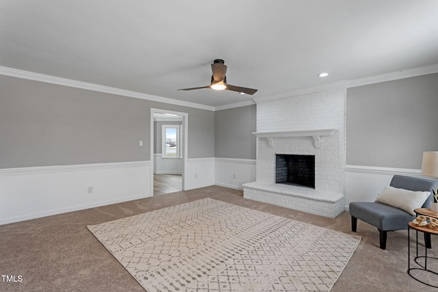 living room featuring light carpet, a brick fireplace, ornamental molding, and ceiling fan