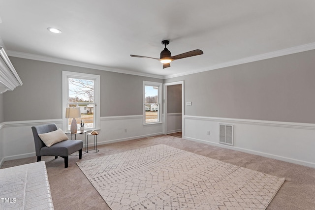 living area with crown molding, light carpet, and ceiling fan