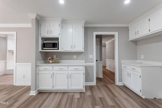 kitchen featuring ornamental molding, white cabinets, and light hardwood / wood-style floors