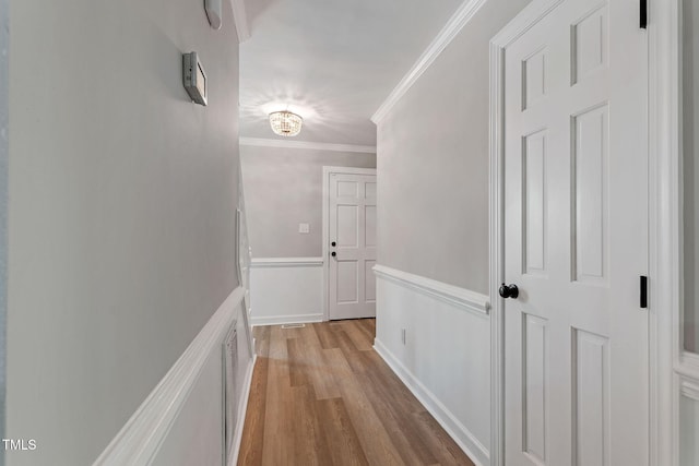 hall featuring crown molding and light hardwood / wood-style floors