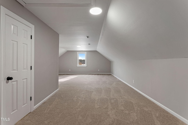 additional living space featuring lofted ceiling and carpet flooring