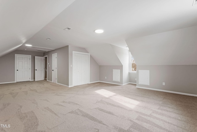 bonus room with vaulted ceiling and light carpet