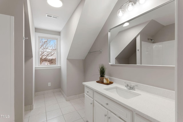 bathroom featuring lofted ceiling, vanity, and tile patterned flooring