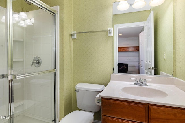 bathroom with vanity, a shower with shower door, and toilet