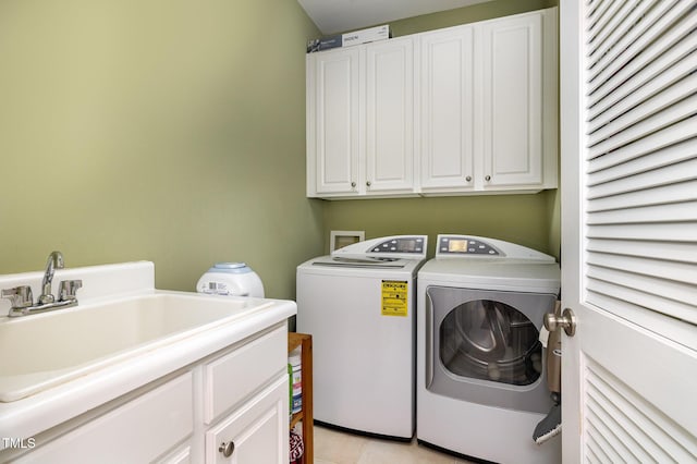 washroom featuring cabinets, light tile patterned floors, sink, and washing machine and clothes dryer