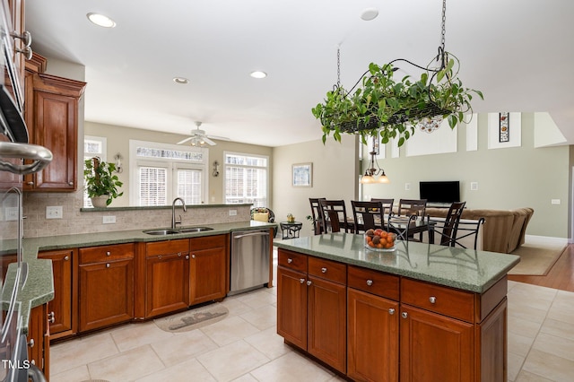 kitchen with tasteful backsplash, dishwasher, sink, and stone countertops