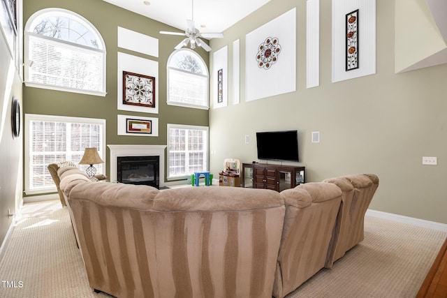 living room featuring ceiling fan and a high ceiling