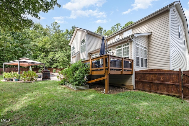 rear view of house with a gazebo, a yard, and a wooden deck