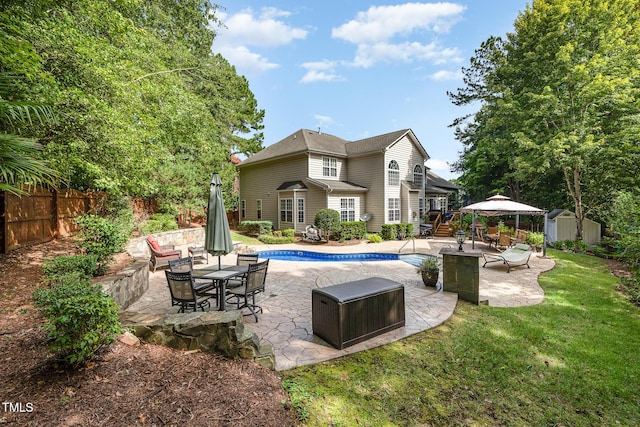 exterior space with a fenced in pool, a yard, a patio area, and a storage shed