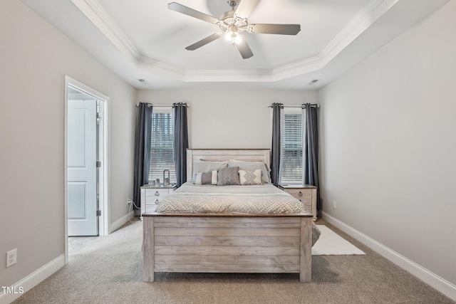 carpeted bedroom featuring ornamental molding, ceiling fan, and a tray ceiling