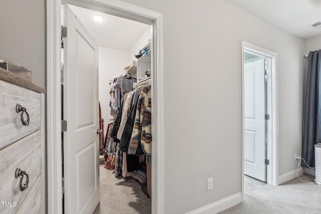 walk in closet featuring light carpet