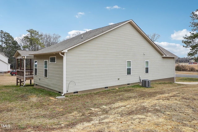 view of side of home featuring central AC and a lawn