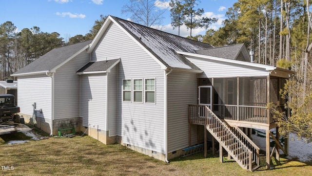 back of property with a yard and a sunroom