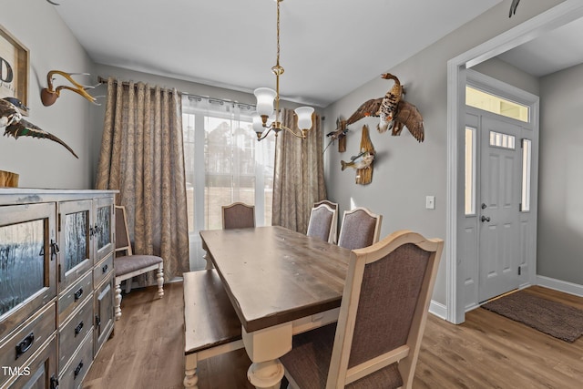 dining area with wood-type flooring and a chandelier