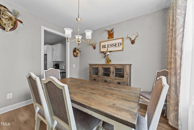 dining space with a notable chandelier and dark hardwood / wood-style floors