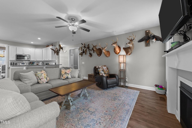 living room with dark wood-type flooring and ceiling fan