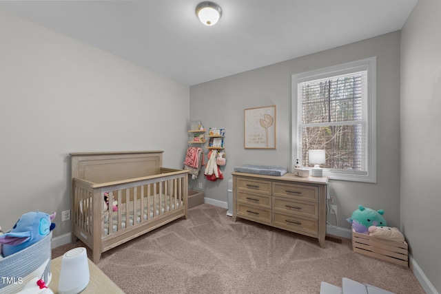 bedroom featuring light carpet and a nursery area