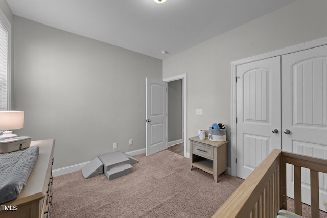 carpeted bedroom featuring a closet and a nursery area