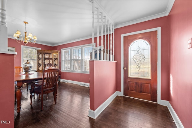 entrance foyer featuring ornamental molding, a chandelier, and dark hardwood / wood-style flooring