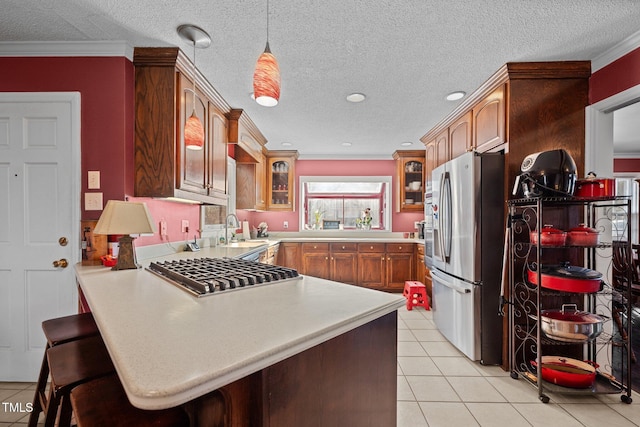 kitchen with pendant lighting, sink, a kitchen breakfast bar, stainless steel appliances, and kitchen peninsula