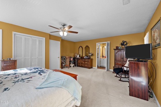 bedroom with ceiling fan, connected bathroom, light carpet, and a closet