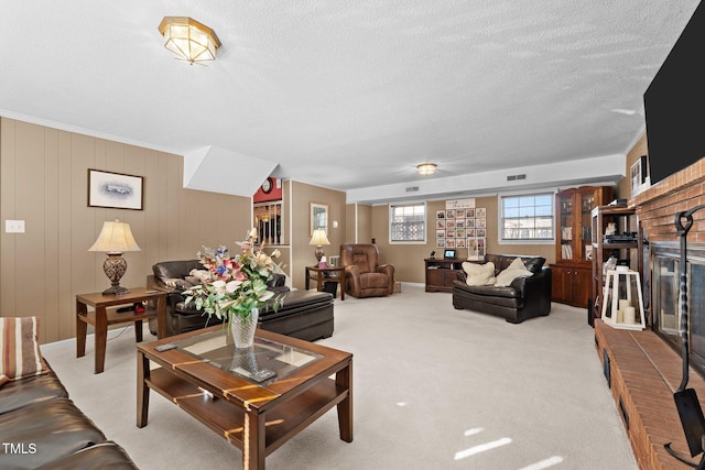 carpeted living room with a brick fireplace and a textured ceiling