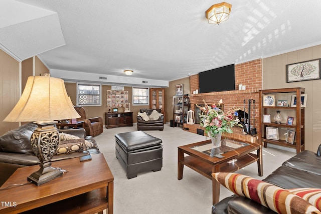 carpeted living room featuring a brick fireplace and a textured ceiling