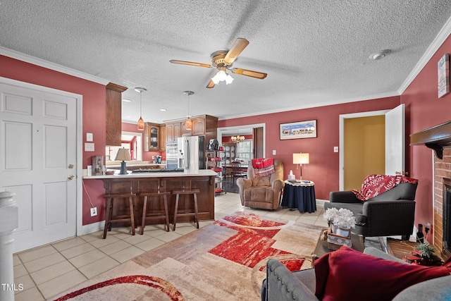 living room with light tile patterned floors, crown molding, a textured ceiling, and ceiling fan