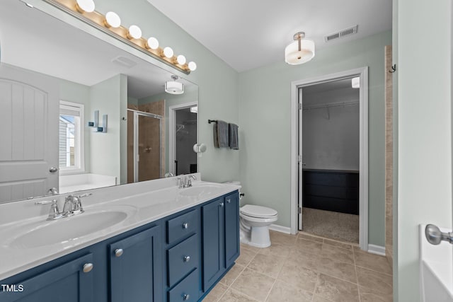 bathroom featuring walk in shower, vanity, toilet, and tile patterned flooring