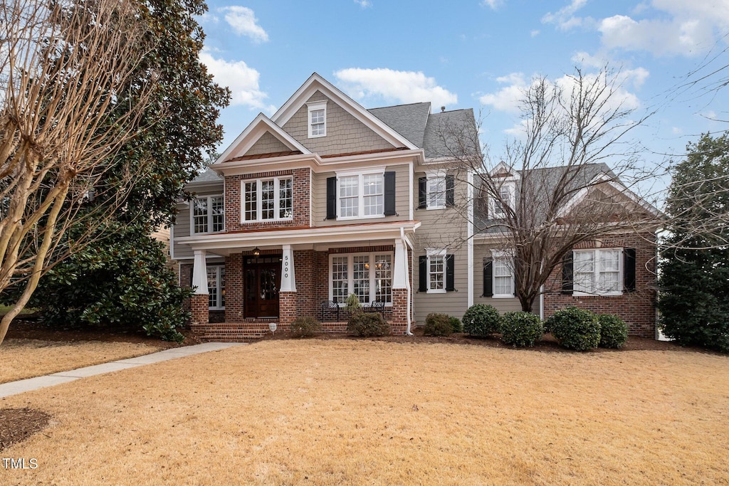 craftsman inspired home featuring a front lawn and a porch