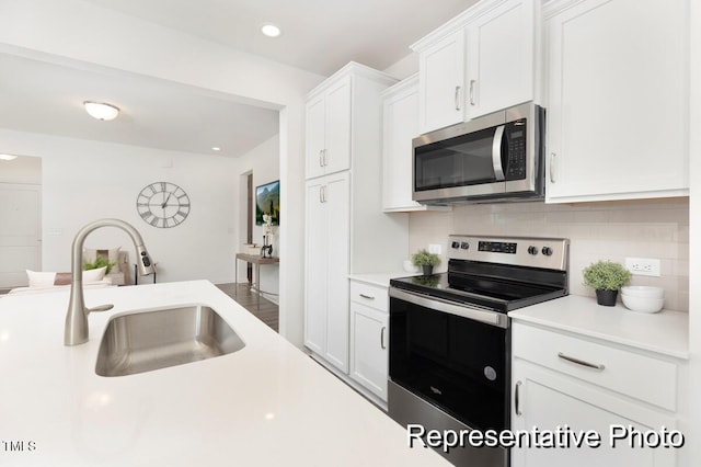 kitchen with backsplash, sink, white cabinetry, and appliances with stainless steel finishes