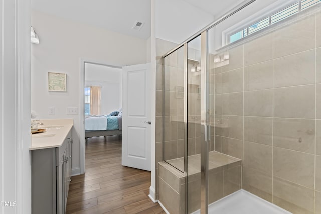 bathroom featuring hardwood / wood-style flooring, vanity, and a shower with door