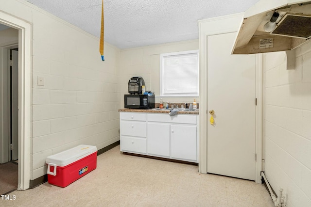 kitchen featuring white cabinets, a textured ceiling, and sink