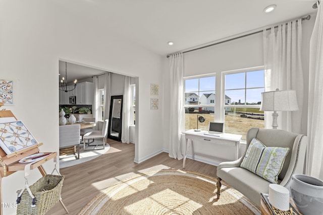 living area with an inviting chandelier and light wood-type flooring