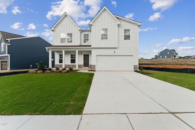 view of front of house with a garage, a front yard, and covered porch