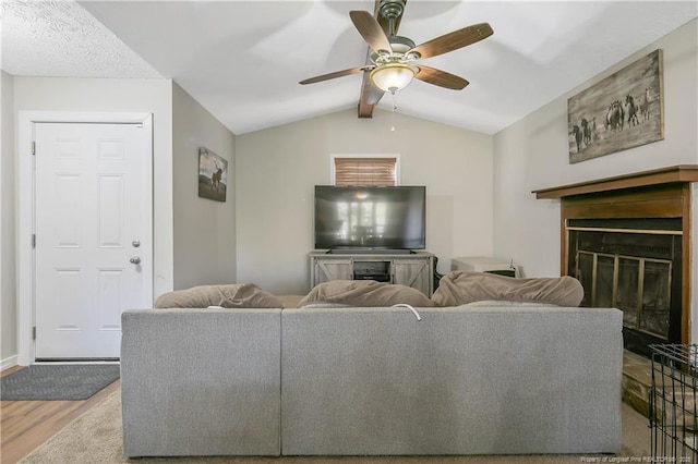 living room with light hardwood / wood-style floors, ceiling fan, and vaulted ceiling with beams