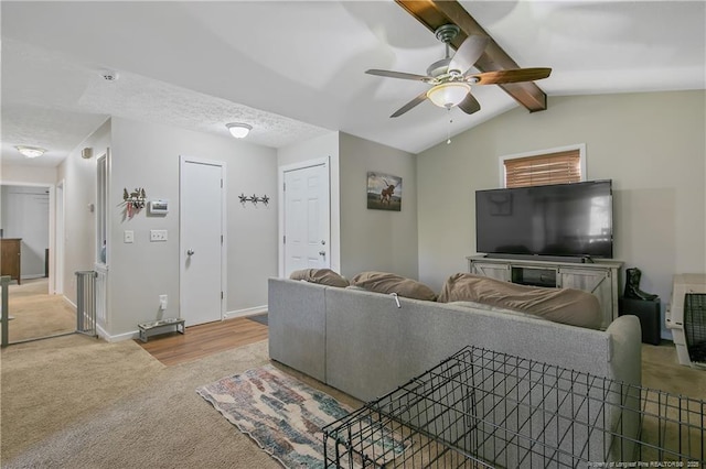 living room with carpet floors, a textured ceiling, ceiling fan, and vaulted ceiling with beams