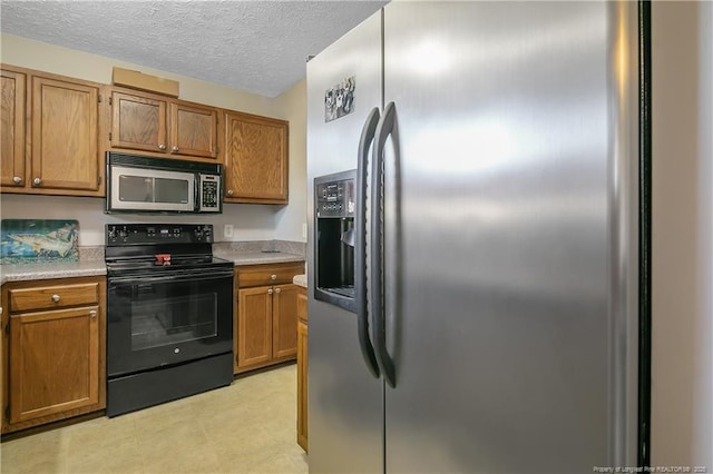 kitchen with a textured ceiling and appliances with stainless steel finishes