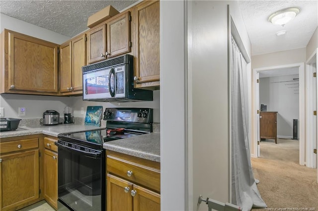 kitchen featuring black electric range oven, light colored carpet, and a textured ceiling