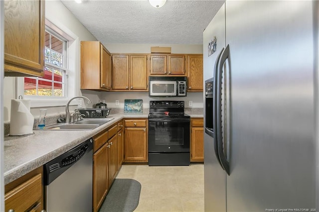 kitchen with sink, a textured ceiling, and appliances with stainless steel finishes