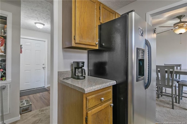 kitchen with ceiling fan, light colored carpet, a textured ceiling, and stainless steel fridge with ice dispenser