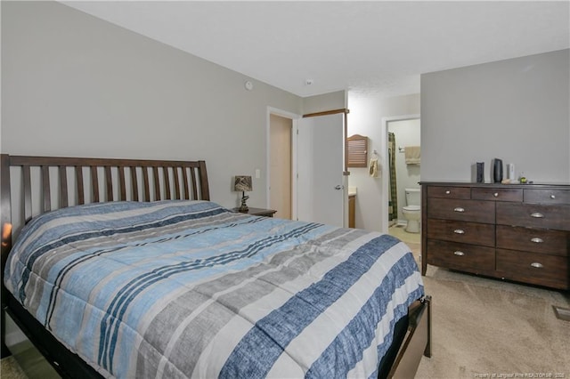 carpeted bedroom featuring ensuite bath