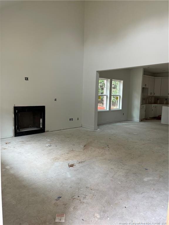 181 Pinecrest Dr, Carthage, NC 28327 - unfurnished living room featuring a towering ceiling and a fireplace