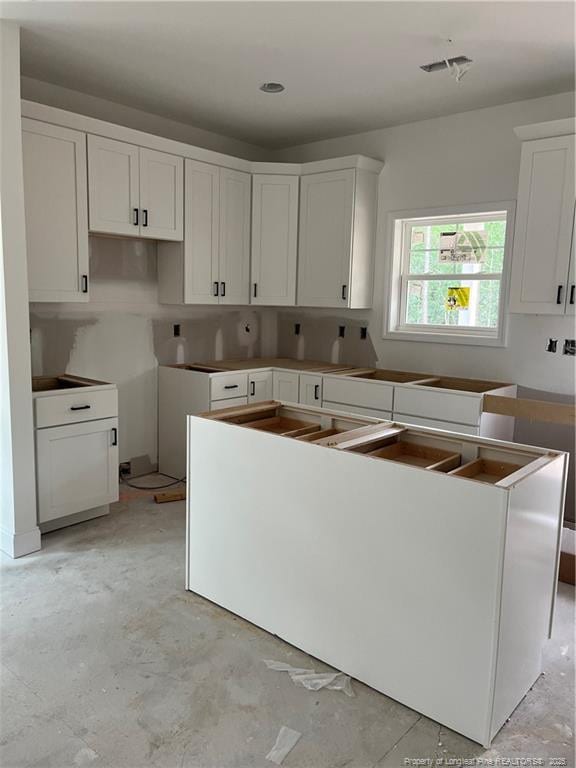 181 Pinecrest Dr, Carthage, NC 28327 - kitchen with white cabinetry and concrete flooring