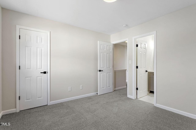 unfurnished bedroom with light carpet and ensuite bathroom