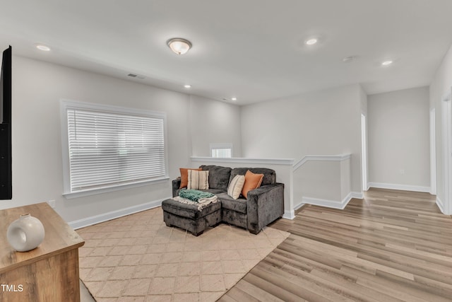 living area with recessed lighting, light wood-type flooring, baseboards, and visible vents