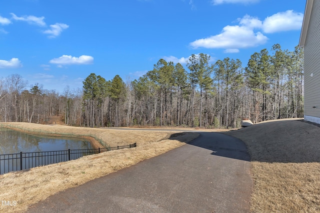 view of street with a wooded view and a water view