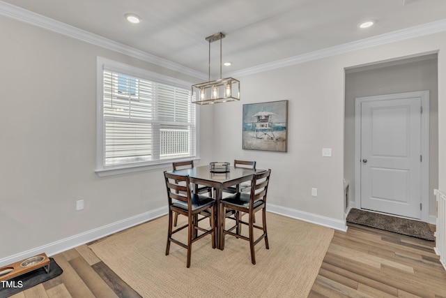 dining room with light wood-type flooring, baseboards, and ornamental molding