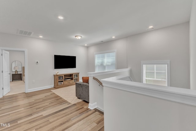 hallway with visible vents, recessed lighting, baseboards, and light wood-style floors