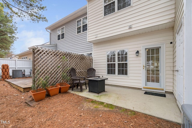 rear view of property with an outdoor fire pit, central AC, and a patio